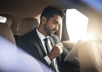 Executive passenger working in luxury car backseat